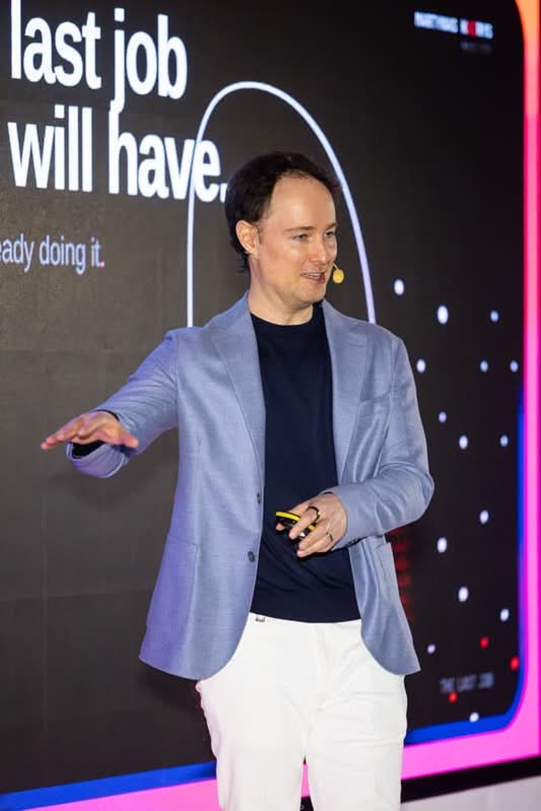 Martynas Kairys on the Vilnius AI Summit stage next to the line 'the last job you will have'