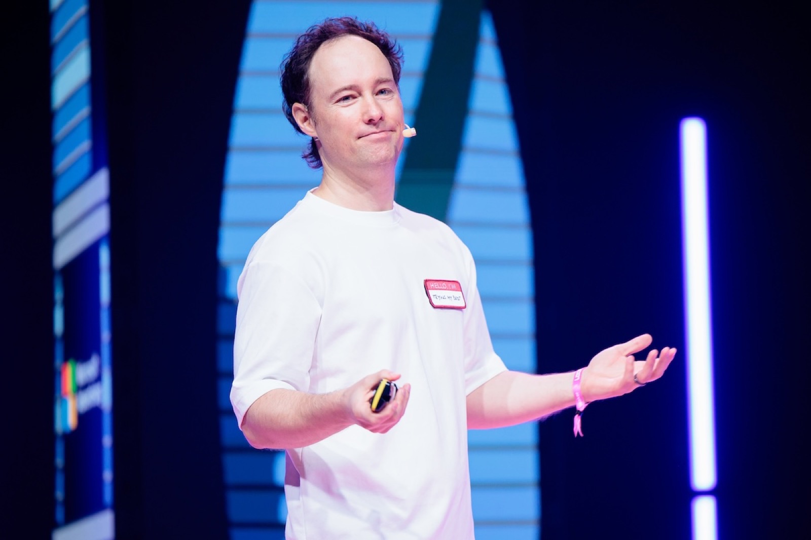 Martynas Kairys on the LOGIN 2026 stage, gesturing mid-talk with a headset mic